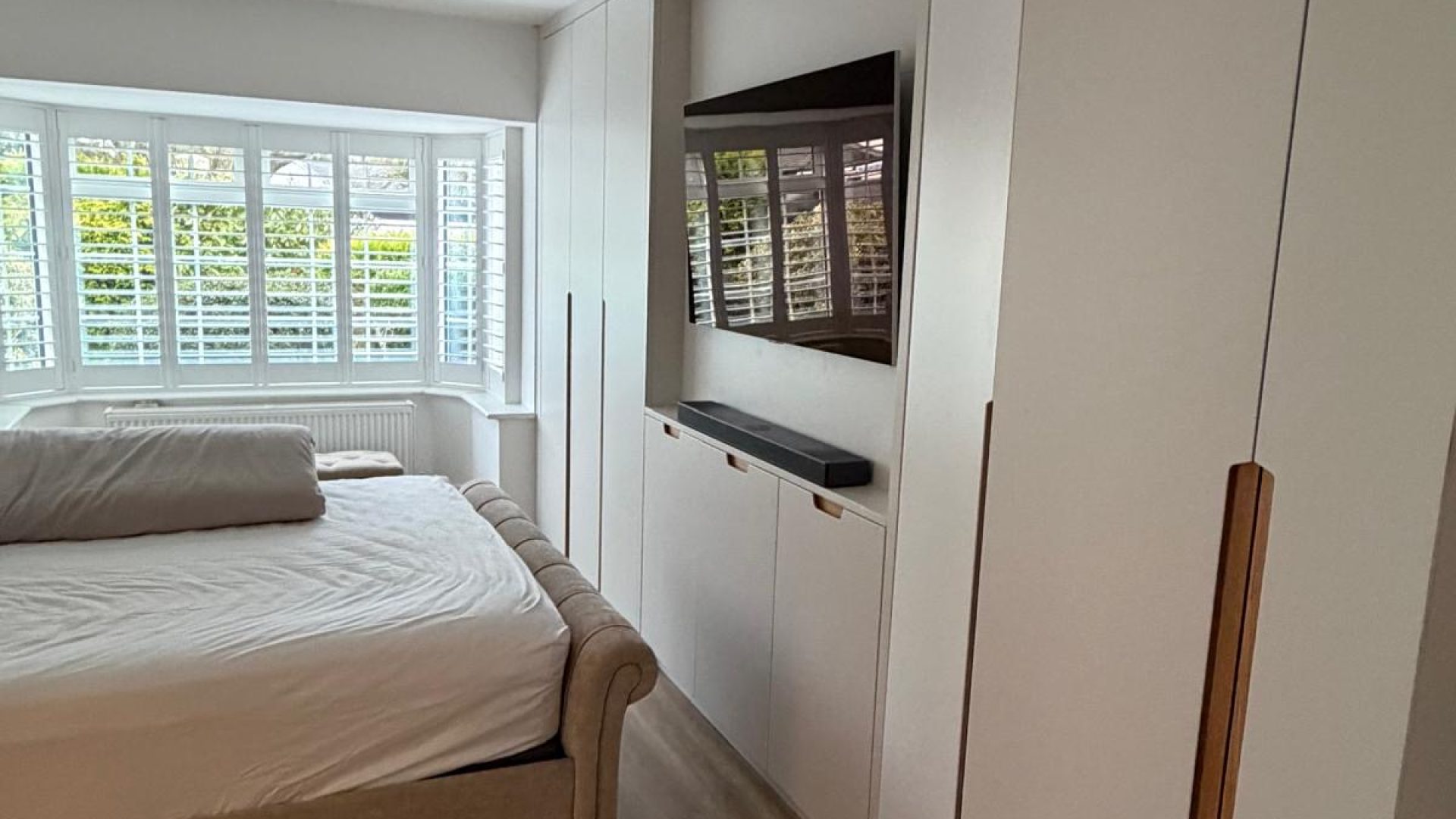 Media unit with fitted wardrobes and plantation shutters